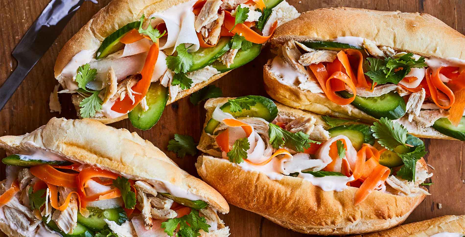 Banh mi garni de légumes marinés, herbes fraîches et viande dans un pain croustillant
